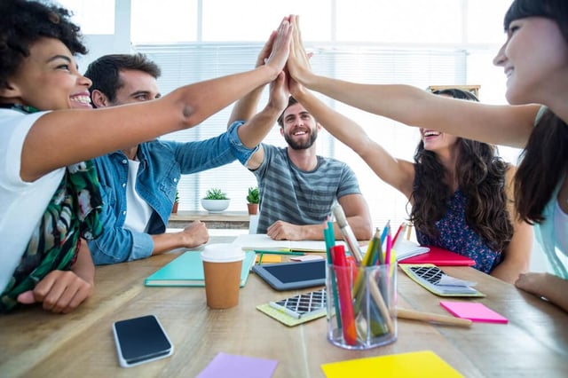 A creative business team putting hands together — the in-house team I want to build with